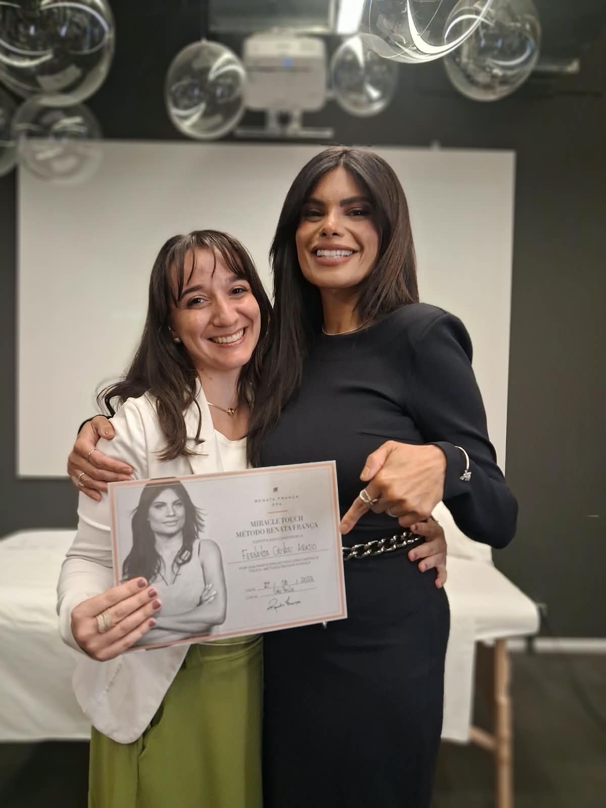 Fernanda Crivari com Renata França, recebendo o certificado Miracle Touch do Método Renata França